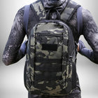 Gros plan sur le dos d'une personne portant un sac rando 20l de couleur camouflage. — vue 7
