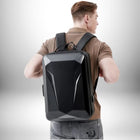 Un jeune homme porte un sac à dos rigide homme noir, dos à la caméra. Le sac est angulaire avec une finition brillante. — vue 6