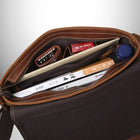 Gros plan de l'intérieur d'un sac bandoulière homme cuir marron, avec des livres, des clés et d'autres objets personnels. — vue 6