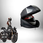 Un motard sur une moto noire, à côté d'un sac à dos moto rigide noir et gris contenant un casque intégral. — vue 5