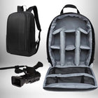 Un sac à dos photo reflex noir ouvert, avec des compartiments rembourrés pour équipements, accompagné d'un sac à dos fermé et d'une caméra. — vue 2