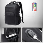 Une photo d'un sac à dos noir avec des port USB de charge. Le sac à dos est connecté à un téléphone via un câble, également présente une batterie externe à l'intérieur de la poche arrière du sac à dos.
— vue 3