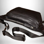 Un sac banane cuir homme noir en gros plan, avec une bandoulière noire tissée et une fermeture éclair argentée.
— vue 5