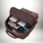 Un sac à dos en toile marron ouvert, rempli d'ordinateurs portables, de carnets, d'une bouteille d'eau et d'autres effets personnels. Le sac est présenté comme potentiellement un bagage a main easy jet. — vue 5