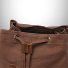 L'image montre un sac à dos en toile marron. Le sac est en gros plan, et l'accent mis sur le dessus ouvert et les cordons de serrage en cuir à l'avant. La couleur de la toile est une nuance riche de brun, tandis que le cuir est un tan plus foncé. Les parties supérieures du sac à dos contiennent aussi des œillets en laiton ainsi que les cordons de serrage en eux. — vue 3