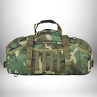 Un sac de voyage robuste en camouflage bois. Il a des sangles Molle et une poignée matelassée et des fermetures ajustables.
— vue 2