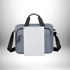 Un cartable pour enseignant gris clair est présenté avec une tablette blanche au centre. Il est équipé d'une bandoulière noire et de poignées supérieures noires. Les poches sont visibles sur le sac. — vue 7
