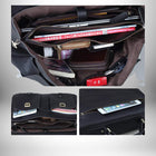 Vue intérieure d'un cartable homme cuir noir, ouvert pour montrer de nombreux objets à l'intérieur, y compris un ordinateur portable, un magazine, un portefeuille, des cigarettes, un téléphone portable et d'autres petits objets. Le cartable est également présenté avec des poches extérieures et un détail de fermeture éclair. — vue 6