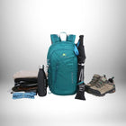 A teal backpack sits among other items, including hiking boots, a water bottle, hiking poles, and clothes, suggesting a gear setup for a specific outdoor activity. — vue 4