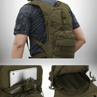 Une personne porte un sac à dos vert olive. Le sac à dos a plusieurs poches et sangles de compression élastiques. Il y a une image d'un gros plan de l'arrière du sac à dos montrant une poche intérieure et une tablette. Il y a un autre gros plan montrant comment le sac à dos s'ouvre. — vue 6