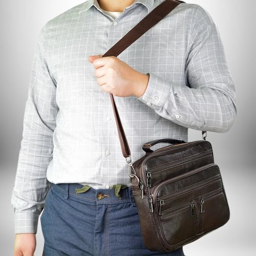 Un homme portant un sac bandoulière homme cuir souple.
