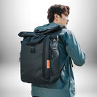 Un homme portant un sac à dos homme travail imperméable noir, avec une veste de couleur bleu-gris. — vue 3