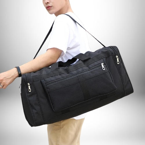 Un homme porte un sac homme sport noir sur l'épaule.
