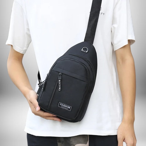 Un homme portant un sac de sport bandoulière noir sur une chemise blanche.