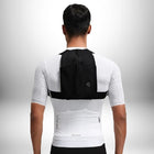 Un homme vu de dos porte ce qui semble être une veste de sport blanche avec des bretelles noires, et un petit **sac à dos running** noir. — vue 2