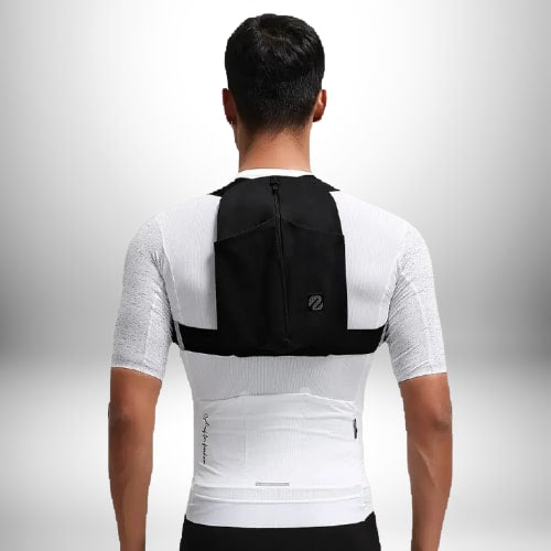 Un homme vu de dos porte ce qui semble être une veste de sport blanche avec des bretelles noires, et un petit **sac à dos running** noir.