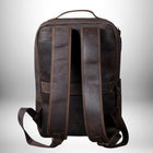 Vue arrière d'un sac à dos en cuir marron foncé ou de type cuir vieilli, avec des bretelles et une poignée supérieures. — vue 4