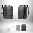 Deux sacs à dos gris, un ordinateur portable, une tablette et deux objets blancs sont posés sur un fond blanc avec un dégradé gris.
 — vue 4