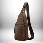 Image d'un petit sac bandoulière cuir marron foncé. Le sac est en cuir vieilli avec une poche zippée sur le devant. La sangle est également en cuir marron avec le nom "SCHIATU" imprimé dessus. — vue 2