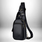 Un petit sac bandoulière cuir​ noir avec des fermetures éclair dorées, des anneaux et une bandoulière noire. Il y a un logo sur le devant du sac. — vue 8