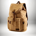Image d'un sac a dos coton beige avec pochettes et fermetures. Le sac est posé contre un arrière plan dégradé du blanc au gris. — vue 1