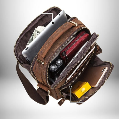 Un sac de ville homme marron en cuir ouvert, révélant un iPad, de l'argent, un portefeuille rouge, un rasoir électrique, un téléphone portable, et un paquet de cigarettes.
