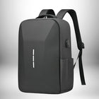 Un sac à dos antivol noir en forme de rectangle avec des angles. Le sac a une série de trois lignes blanches verticales au milieu. Il a une petite poche sur le côté et une connexion USB. Il possède également des bretelles noires et une poignée en haut.
 — vue 8