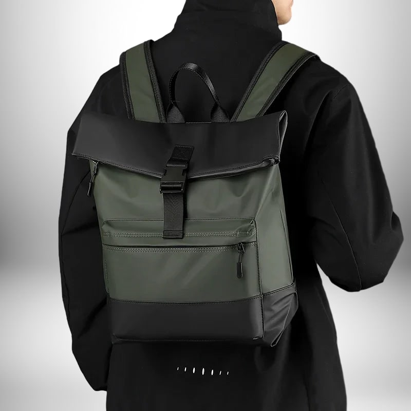 Une photo prise d'un homme de dos qui porte un sac à dos business,sac a dos business noir et vert. Le sac à dos est de conception moderne et comprend une section noire sur le dessus et le bas ainsi que des bretelles noires et vertes et une attache bouclée.