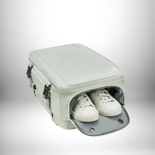 Un sac à dos cabine easyjet blanc avec une poche latérale ouverte contenant deux chaussures de sport blanches. Le sac est posé sur un fond dégradé blanc et gris.