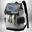 A stylish backpack with a black top flap, gray body, and black accents. It has a front zipper, side pockets, and adjustable straps. "MOYVI" is visible on a label. — vue 8