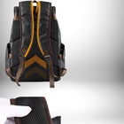 A digitally enhanced image showcases the rear view of a black leather backpack. The backpack is equipped with brown straps and features a mesh back panel, accentuated with an outline-like overlay that highlights its design. The backpack has the look of being stylish while hinting at a function for comfort. — vue 6