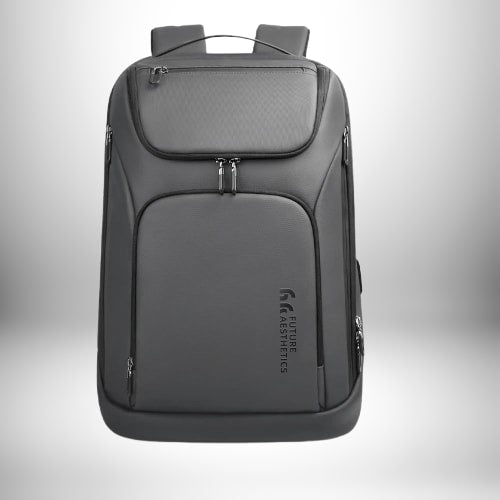 Un sac à dos professionnel homme gris élégant avec plusieurs compartiments et fermetures éclair. Le sac porte une petite signature 'FUTURE AESTHETICS' sur sa partie inférieure.
