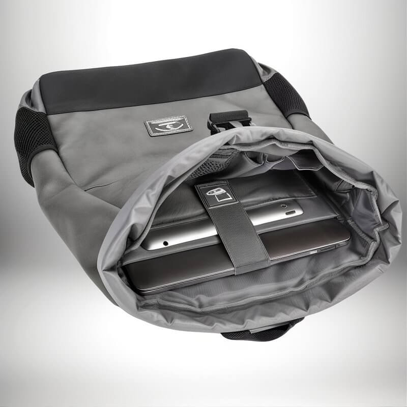 A close-up shot of a modern backpack, opened to reveal a laptop and tablet securely held inside. The backpack is gray with black accents, boasting a sleek design. The interior features a dedicated compartment for electronics, secured by a strap. The open flap of the backpack showcases a minimalist, functional design, perfect for holding a laptop or tablet.