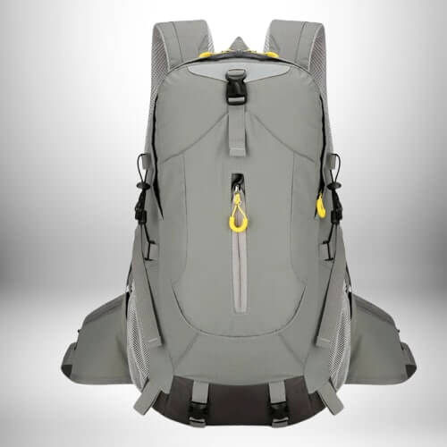 A gray hiking backpack with yellow accents. The backpack has a front zip pocket, mesh side pockets and multiple straps. The backpack is centered and in the foreground, against a gradient white background.