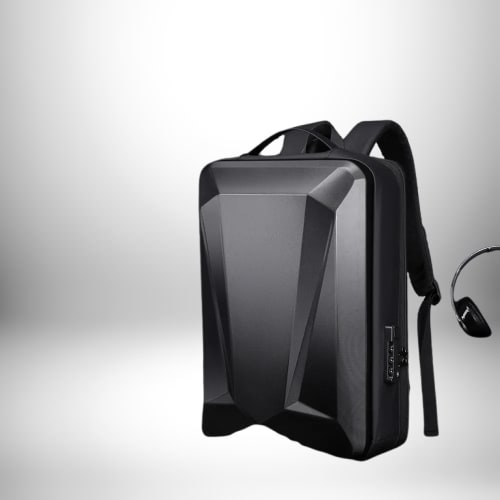 Image d'un sac a dos jeu video​ noir avec un design angulaire et des bretelles noires, ainsi qu'un casque noir. Le sac a dos est sur un fond gris dégradé.