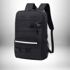 Un sac à dos noir avec plusieurs poches, des sangles et une bande réfléchissante blanche. Il a un cadenas au sommet avec une pochette en filet latérale et un port USB. Ce pourrait être un **sac à dos skate**.
 — vue 3