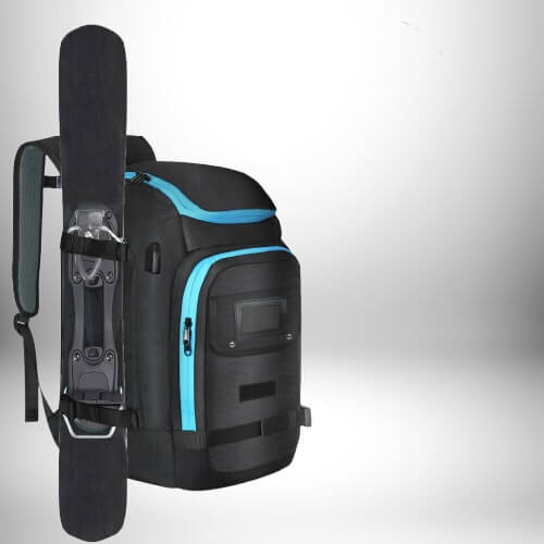 Un sac à dos snowboard noir se tient à l'avant dans une position verticale sur un fond gris et blanc. Le sac à dos a une fermeture éclair et des accents bleu clair. Une planche est fixée latéralement au sac à dos.