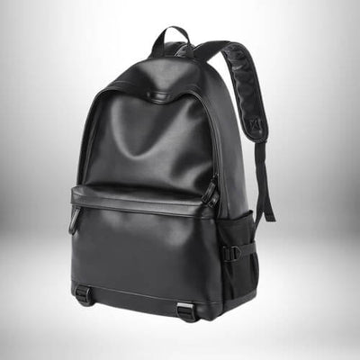 Un sac à dos simili cuir homme noir, élégant, avec une poche frontale, des bretelles rembourrées et des détails métalliques.