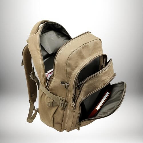 Un sac a dos zip ouvert, permettant de voir son contenu. De couleur beige, il possède plusieurs compartiments et une poche frontale ouverte contenant des documents, et un livre