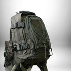 Un sac à dos de randonnée homme de couleur sombre, en gros plan, visible sur un fond flou. — vue 2