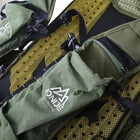 Gros plan d'un sac à dos de course vert avec le logo de la marque. Le sac à dos a plusieurs poches et sangles. Certains des détails incluent une poche de rangement pour bouteille d'eau, une doublure en filet jaune et le mot "running". — vue 6