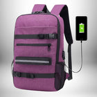 Un sac à dos skate violet avec des bandes noires, des boucles, une poche et un insert réfléchissant. Un téléphone noir affiche une batterie en charge et est connecté au sac à dos.
 — vue 8