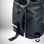 L'image montre un sac a dos metal avec une fermeture éclair argentée sur le côté et une boucle de fermeture. Le sac est noir et présente un bord de cordon de serrage. Une silhouette simple d'un visage d'homme barbu apparaît dans le coin inférieur droit. — vue 7