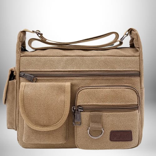 Un sac de ville homme en toile de couleur beige, avec plusieurs poches à fermeture éclair et une bandoulière réglable.
