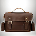 Un cartable homme moderne en cuir marron, avec des boucles dorées et une bandoulière amovible. — vue 2