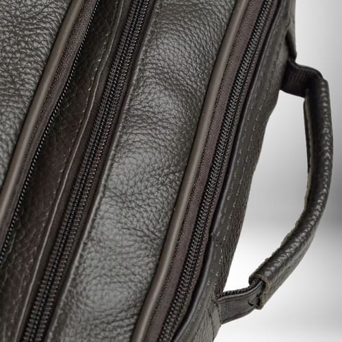 Gros plan sur un sac bandoulière homme cuir souple avec fermetures éclair et une poignée.
