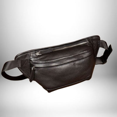 Un sac banane cuir homme noir, avec des fermetures éclair argentées et une bandoulière noire.
