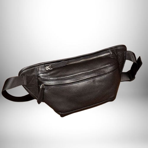 Un sac banane cuir homme noir, avec des fermetures éclair argentées et une bandoulière noire.
