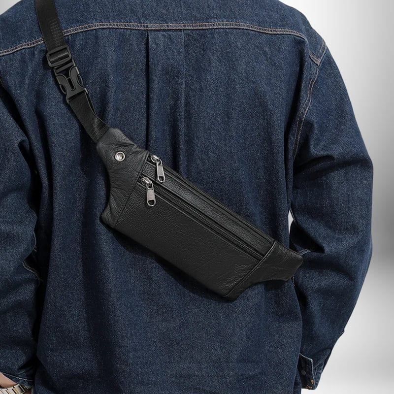 Gros plan d'un homme vu de dos, portant un sac banane noir en cuir sur son dos.