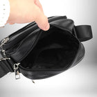 Gros plan d'un sac bandoulière cuir noir homme​ ouvert par une main humaine, révélant l'intérieur noir. — vue 5
